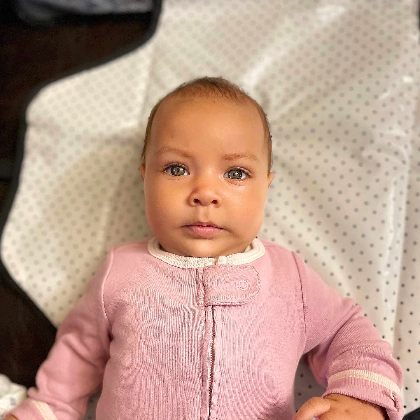 Delilah is registered to the contest to win money with this photo: baby, bodypart, clothing, coat, couch, face, finger, furniture, hand, happy, head, knitwear, longsleeve, pants, person, photography, portrait, sleeve, smile, sweater