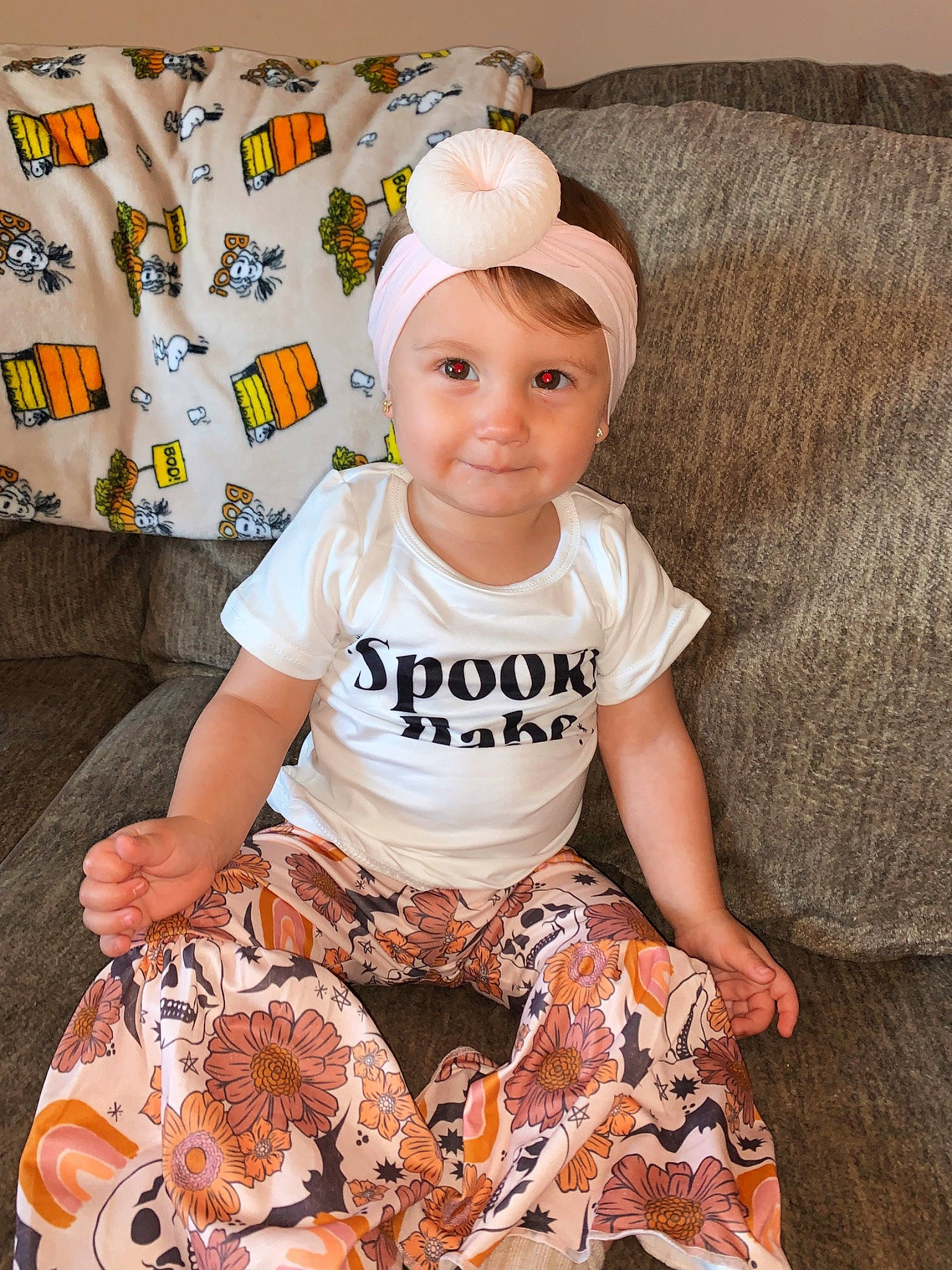 Kamille is registered to the contest to win money with this photo: baby, baby_toddler_clothing, cap, child, costume_hat, couch, event, fashion_accessory, fun, happy, head, headwear, joy, orange, pattern, peach, person, room, sitting, sleeve