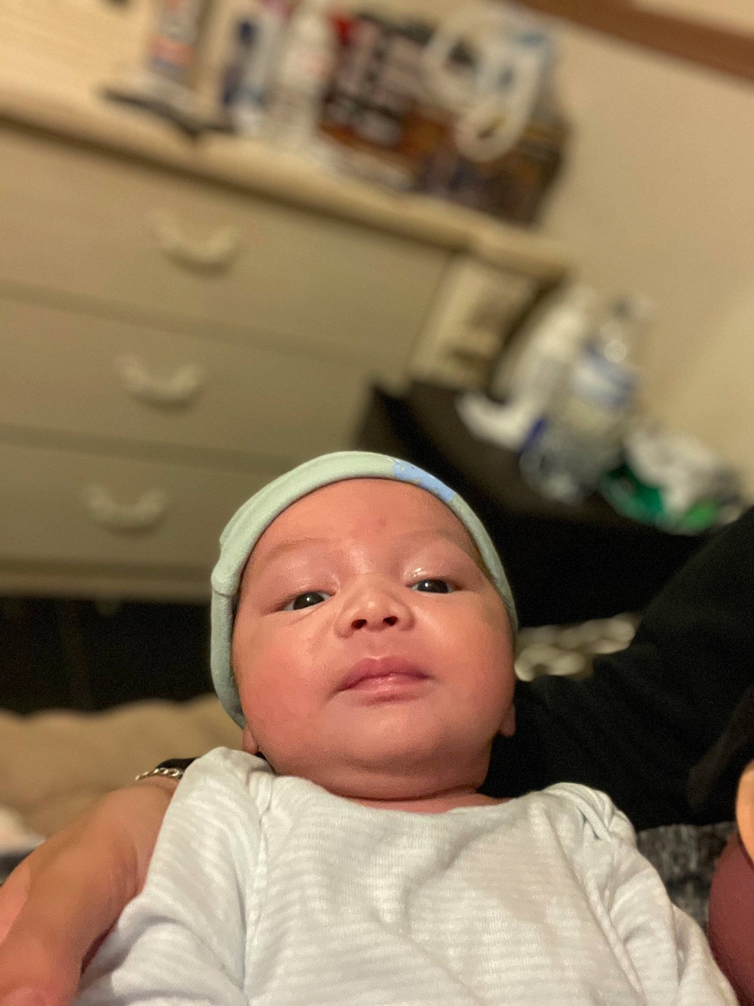 Alan is registered to the contest to win money with this photo: baby, baby_toddler_clothing, cheek, child, comfort, finger, fun, happy, hat, headgear, headwear, linens, person, picture_frame, portrait_photography, room, sitting, skin, thumb, toddler