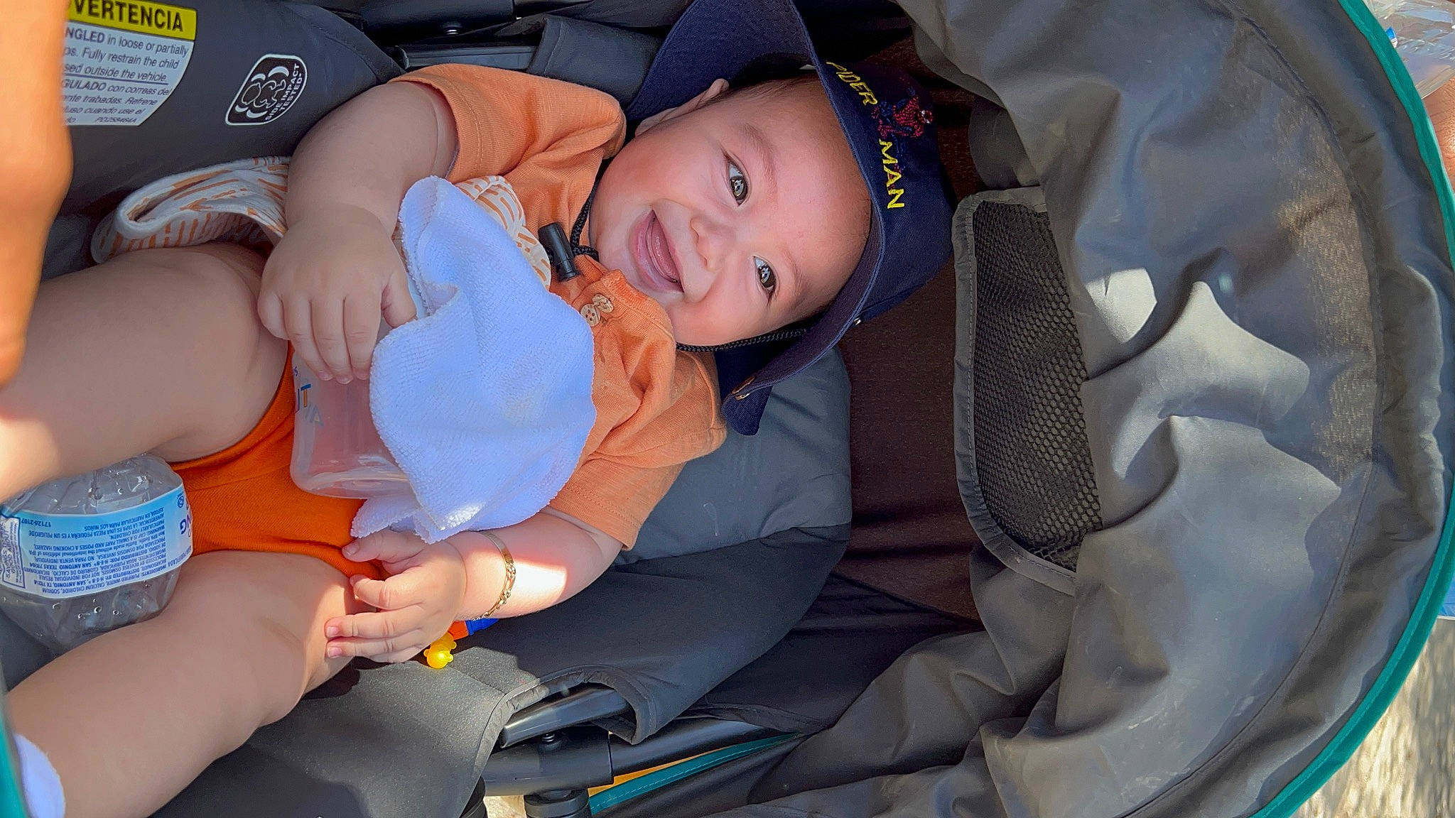 Alan is registered to the contest to win money with this photo: auto_part, baby, baby_carriage, baby_in_car_seat, baby_products, baby_toddler_clothing, car_seat, child, comfort, electric_blue, event, face, finger, fun, hat, head_restraint, headwear, person, sitting, smile