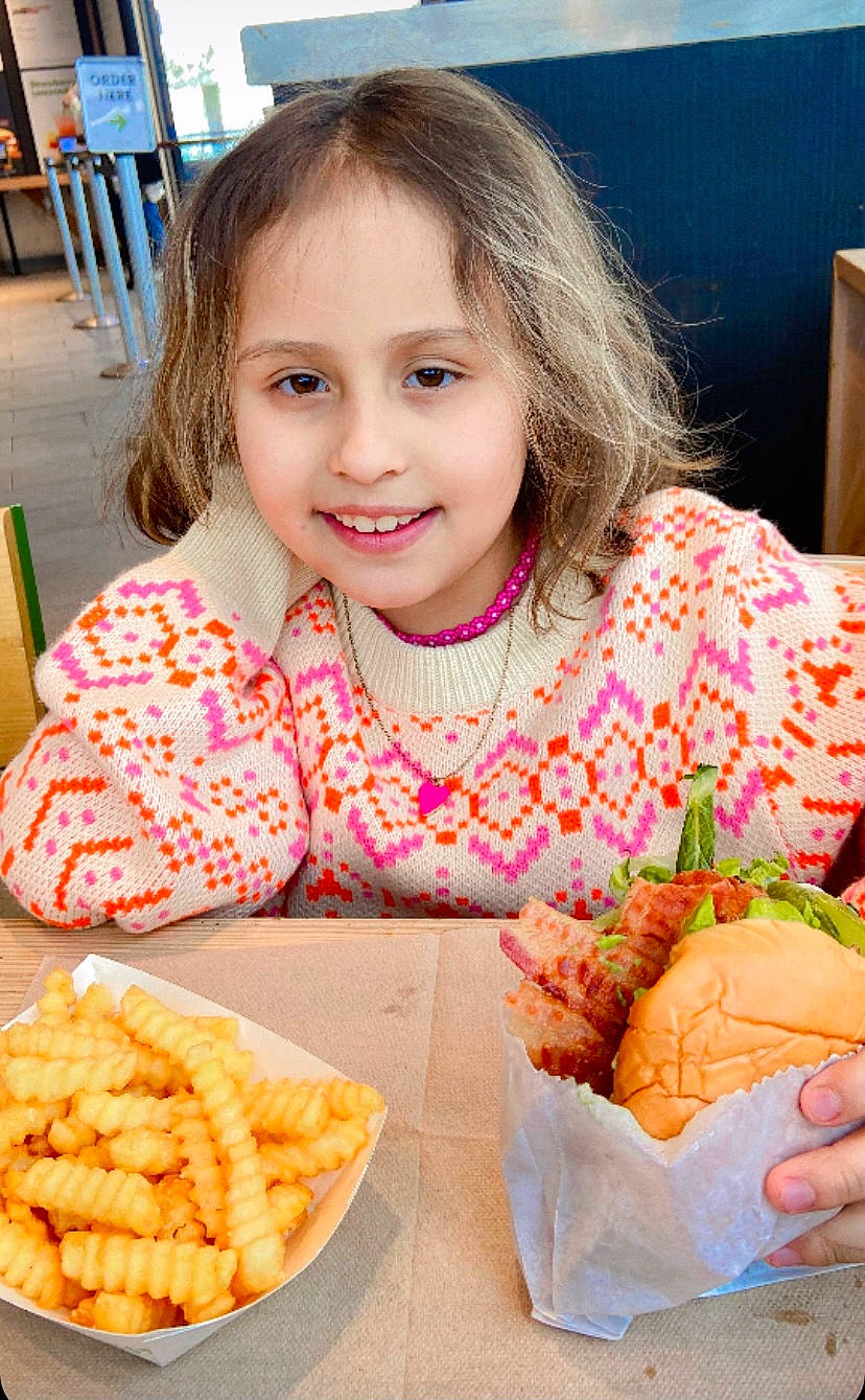 Camilla is registered to the contest to win money with this photo: baked_goods, chair, child, comfort_food, cuisine, dish, finger_food, food, food_craving, happy, ingredient, joy, junk_food, person, plate, recipe, sharing, smile, sweetness, table