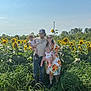 family, child, baby, sunflower_field, outdoor, nature, grass, sunflower, adult, man, woman, casual_clothing, hat, glasses, smile, happy, summer, daylight, plants, portrait