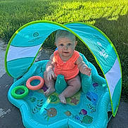 Mazie joined the competition — help win amazing prizes! baby, blue, child, concrete, cute, face, garden, grass, happy, infant, inflatable_pool, orange_clothing, outdoor, play, sitting, summer, sunlight, sunshade, toy_rings, water
