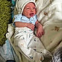 Oliver joined the competition — help win amazing prizes! baby, infant, newborn, clothing, hat, blanket, pajamas, sleepwear, face, hand, lying_down, bed, soft, cozy, cute, expression, indoors, person, small, comfort