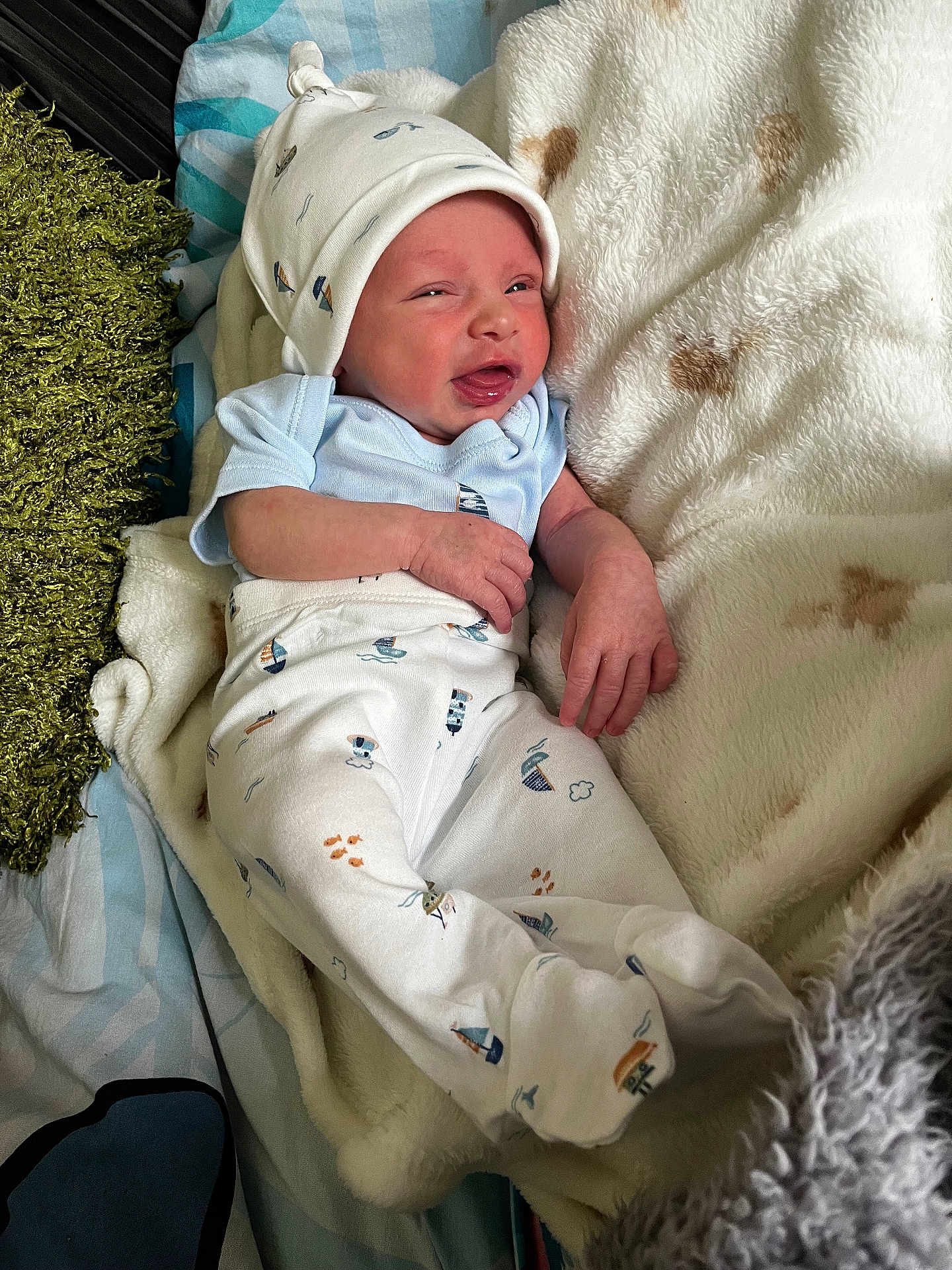 Oliver joined the competition — help win amazing prizes! baby, infant, newborn, clothing, hat, blanket, pajamas, sleepwear, face, hand, lying_down, bed, soft, cozy, cute, expression, indoors, person, small, comfort