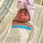 Leonni is registered to the contest to win money with this photo: newborn, baby, infant, wrapped, blanket, hat, bow, striped, sleeping, face, skin, hospital, bed, cute, child, portrait, resting, headwear, soft, indoors