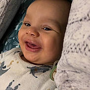 Kaïs a rejoint le concours — aidez-le/la à gagner de superbes lots ! baby, bed, blanket, child, closeup, cute, dinosaur, face, happy, indoors, infant, onesie, pacifier, pillow, portrait, resting, sleepwear, smiling, soft, young