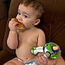 baby, bodypart, bread, couch, cream, cutlery, dessert, diaper, eating, face, finger, food, furniture, hand, head, icing, person, photography, portrait, sweets