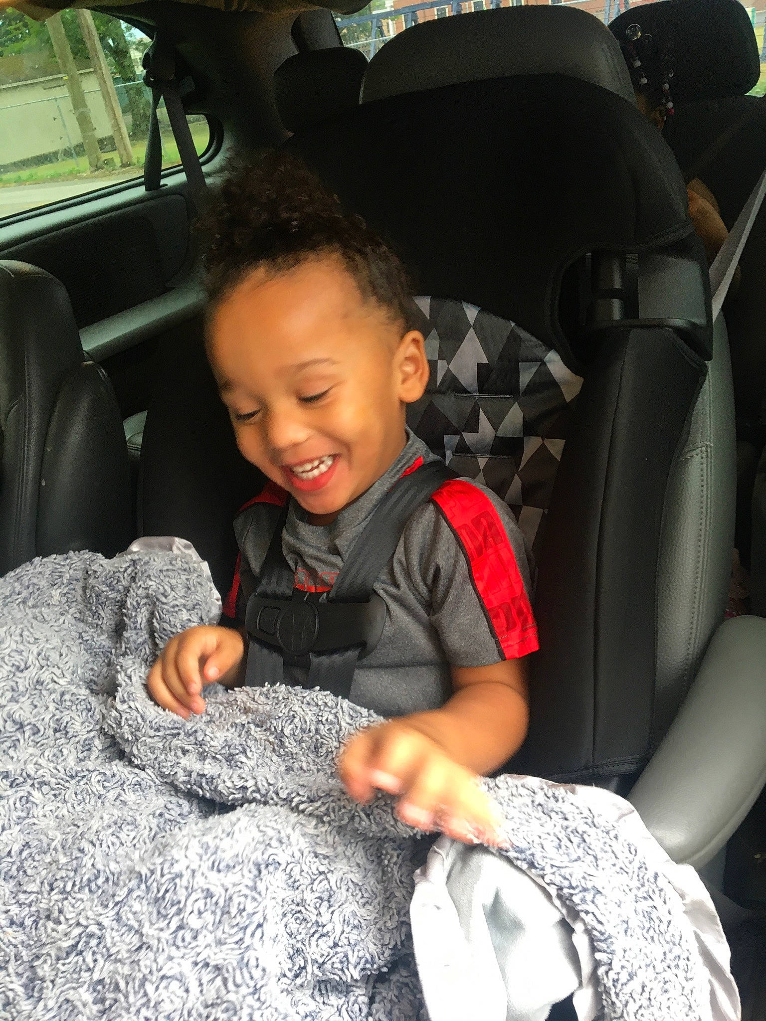 Kobe is registered to the contest to win money with this photo: auto_part, automotive_design, automotive_exterior, car, car_seat, car_seat_cover, comfort, head_restraint, joy, motor_vehicle, person, personal_luxury_car, plant, sleeve, smile, steering_part, steering_wheel, tints_and_shades, toddler, vehicle