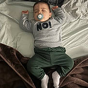 Samir a rejoint le concours — aidez-le/la à gagner de superbes lots ! baby, bed, blanket, child, clothing, cozy, cute, green_pants, indoor, infant, pacifier, peaceful, person, pillow, portrait, relaxation, rest, sleeping, sweater, white_socks