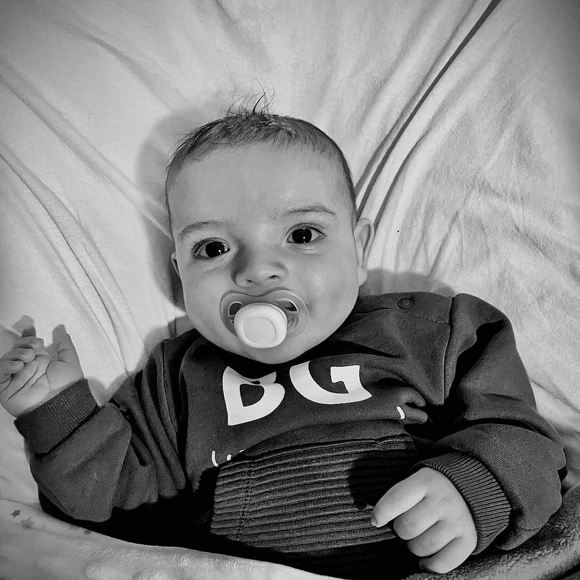 Samir participe au concours pour gagner de l'argent avec cette photo : baby, black_and_white, blanket, child, clothing, cozy, cute, expression, face, hand, indoors, infant, looking, monochrome, pacifier, portrait, sitting, sleeve, soft, young