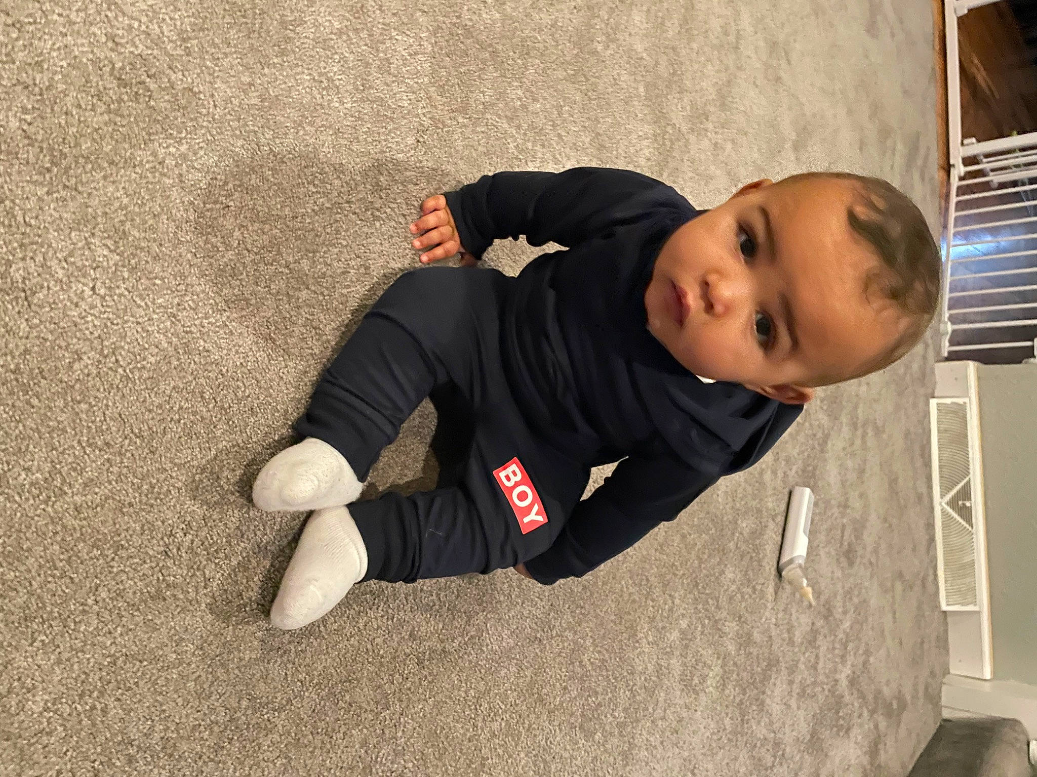 Kalvin joined the competition — help win amazing prizes! asphalt, baby, baby_toddler_clothing, child, comfort, flooring, fun, jacket, knee, person, sitting, sleeve, sock, t_shirt, toddler, tree, wood