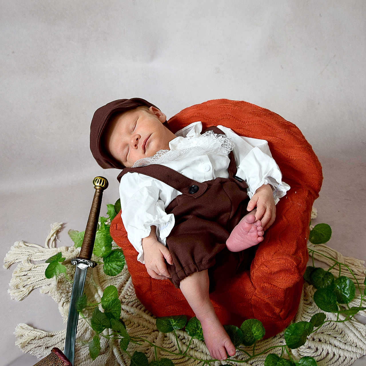 Noah participe au concours pour gagner de l'argent avec cette photo : baby, brown_clothing, cap, cream_rug, cute, decorative, gold_coins, gold_rings, green_leaves, indoor, infant, orange_chair, peaceful, portrait, props, resting, sleeping, toy_sword, treasure_chest, vintage_outfit