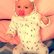 Jade participe au concours pour gagner de l'argent avec cette photo : baby, child, pacifier, white_bow, onesie, cherry_pattern, pink_cushion, leather_background, footwear, sitting, indoor, cute, infant, clothing, headwear, portrait, young_child, soft_lighting, comfort, expression