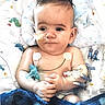 baby, infant, child, hospital, hospital_bed, medical_equipment, monitoring, feeding_tube, nasal_tube, iv, medical_sensors, blanket, pillow, sitting, portrait, face, dark_hair, eyes_open, indoor, healthcare