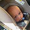 Grey is registered to the contest to win money with this photo: baby, infant, child, car_seat, vehicle, portrait, face, blue_eyes, wide_eyed, looking_at_camera, seated, strapped_in, safety_harness, sunlight, indoor, travel, automobile, close_up, photography, text_overlay