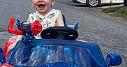 Nicholas joined the competition — help win amazing prizes! toddler, child, toy_car, spiderman, red, blue, outdoor, street, residential_area, happy, smiling, curly_hair, vehicle, playtime, daylight, car_toy, person, fun, cute, joyful