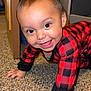 black_clothing, carpet, checkered_pattern, child, crawling, cute, face, floor, furniture, hands, happy, home, indoor, person, playful, red_clothing, smiling, storage_bin, toddler, young_child