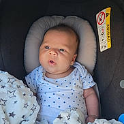 Liam participe au concours pour gagner de l'argent avec cette photo : baby, blanket, car_seat, child, clothing, comfort, cute, expression, face, head_support, indoors, infant, newborn, onesie, portrait, seat, skin, soft_texture, star_pattern, young