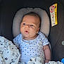 baby, blanket, car_seat, child, clothing, comfort, cute, expression, face, head_support, indoors, infant, newborn, onesie, portrait, seat, skin, soft_texture, star_pattern, young