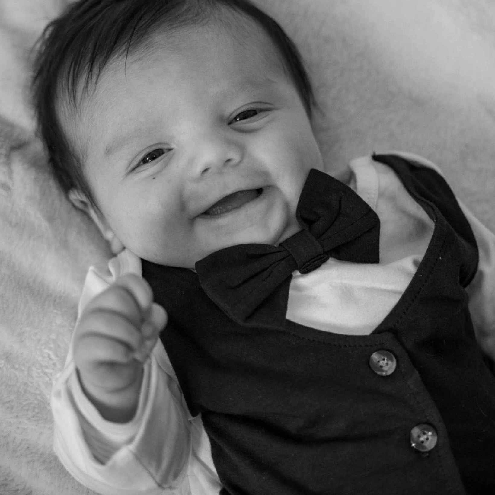 Sacha a rejoint le concours — aidez-le/la à gagner de superbes lots ! accessories, baby, bodypart, bowtie, clothing, coat, face, finger, formalwear, hand, happy, head, person, photography, portrait, shirt, smile, suit, tie, vest