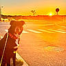 Olaf participe au concours pour gagner de l'argent avec cette photo : dog, sunset, street, sidewalk, collar, leash, road, crosswalk, sun, sky, tree, urban, outdoor, animal, pet, evening, nature, silhouette, calm, scenic