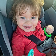Noah is registered to the contest to win money with this photo: toddler, child, car_seat, smile, red_shirt, toy, seatbelt, happy, portrait, indoors, cute, baby, young_child, seat, safety, hands, playful, casual_clothing, closeup, bright