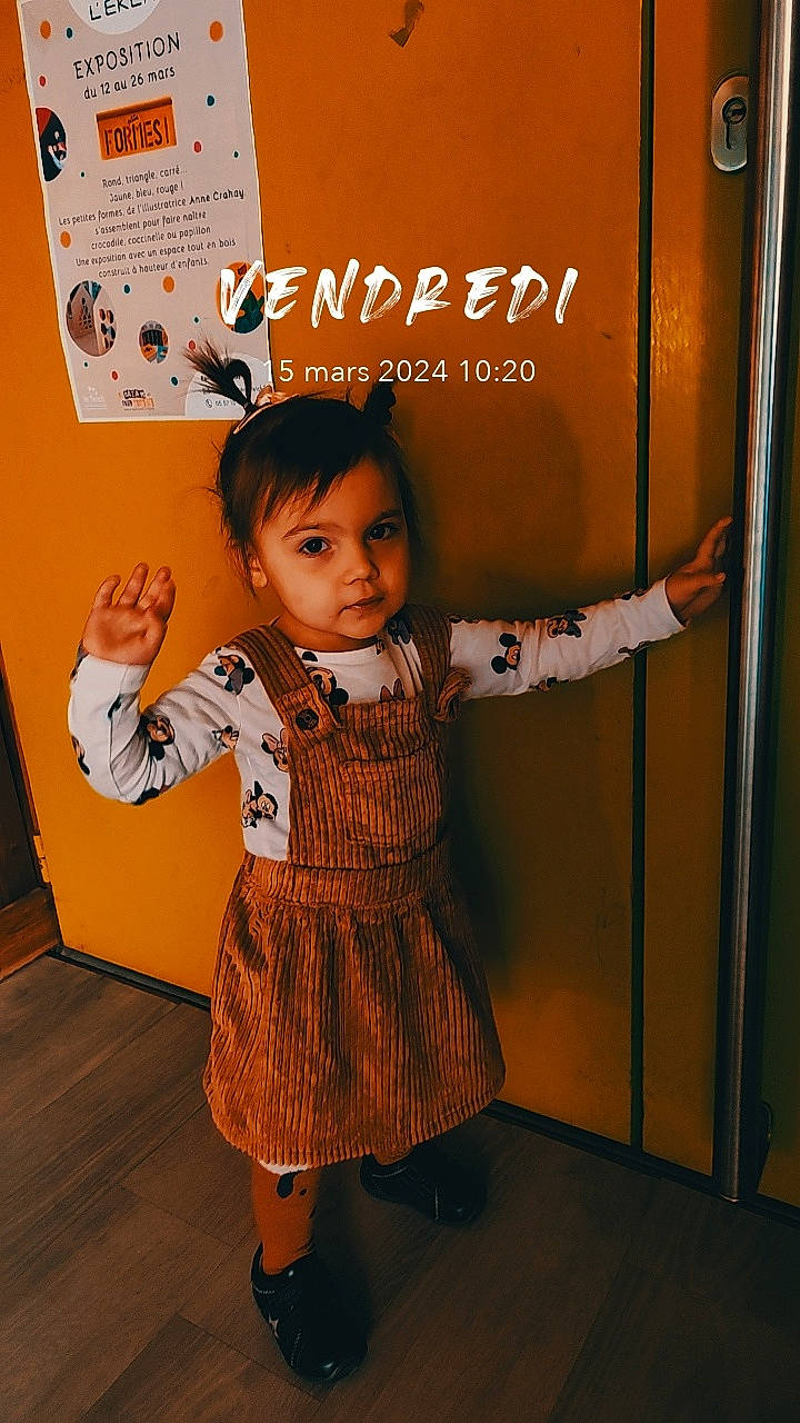 Viktoire participe au concours pour gagner de l'argent avec cette photo : baby_toddler_clothing, child, door, facial_expression, fashion_design, flooring, fun, gas, gesture, happy, human_leg, logo, one_piece_garment, pattern, person, room, sandal, sleeve, sock, thumb