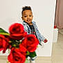 child, boy, smiling, denim_jacket, curly_hair, roses, flowers, indoor, white_wall, tiled_floor, casual_clothing, sneakers, portrait, happy, cute, person, flower_bouquet, young_child, standing, home