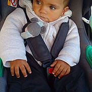 Nolhan a rejoint le concours — aidez-le/la à gagner de superbes lots ! baby, toddler, infant, car_seat, seatbelt, harness, plush_toy, sweater, hoodie, hands, sneakers, shoe, buckle, warning_label, airbag_sticker, short_hair, brown_eyes, portrait, cute, pensive