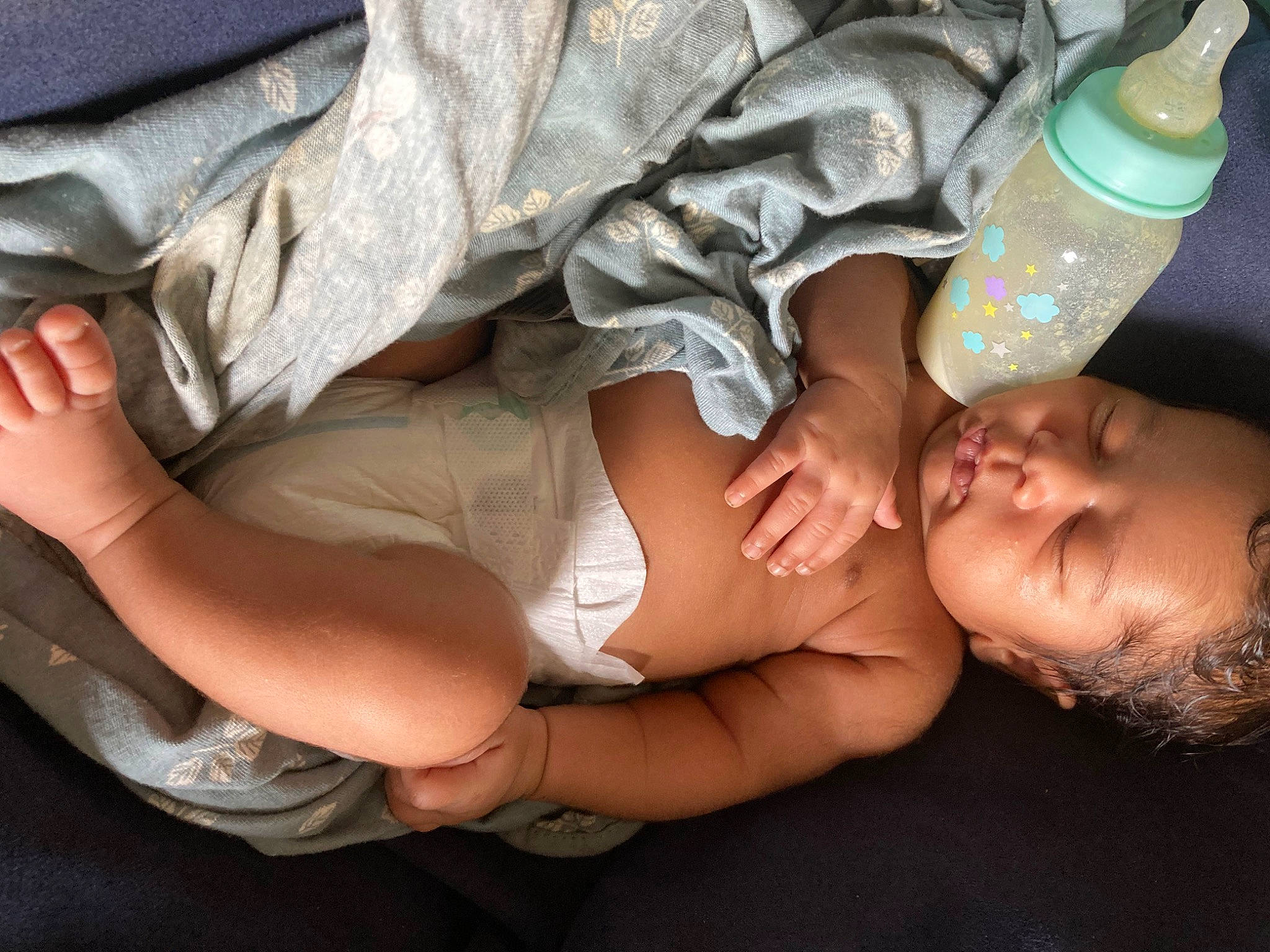 Arie joined the competition — help win amazing prizes! baby, bottle, camouflage, chest, comfort, elbow, finger, gesture, human_body, human_leg, joint, knee, leg, nail, person, plastic_bottle, skin, thigh, toddler, trunk