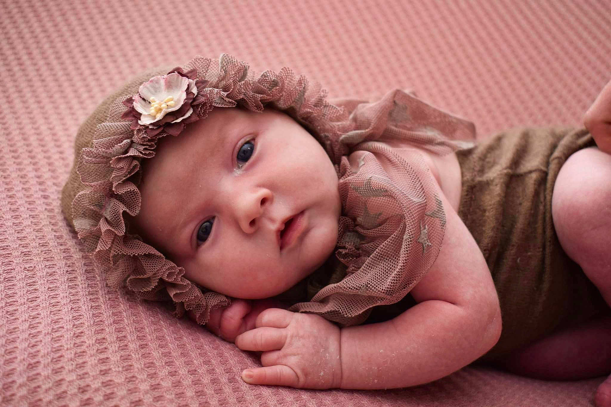 Billie participe au concours pour gagner de l'argent avec cette photo : arm, baby, baby_toddler_clothing, cheek, comfort, eye, eyelash, face, finger, flash_photography, gesture, hand, headwear, human_body, lip, mouth, nose, person, pink, skin