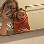 Elowyn is registered to the contest to win money with this photo: baby, bathroom, casual, child, deodorant, glasses, hair, hand, mirror, orange, person, phone, reflection, selfie, tile, toiletries, toothbrush, towel, wall, young_adult