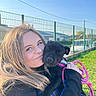 Alba a rejoint le concours — aidez-le/la à gagner de superbes lots ! woman, puppy, dog, outdoor, sunlight, smile, fence, grass, leash, black_dog, happy, portrait, casual_clothing, nature, holding, pet, daylight, young_adult, friendly, park