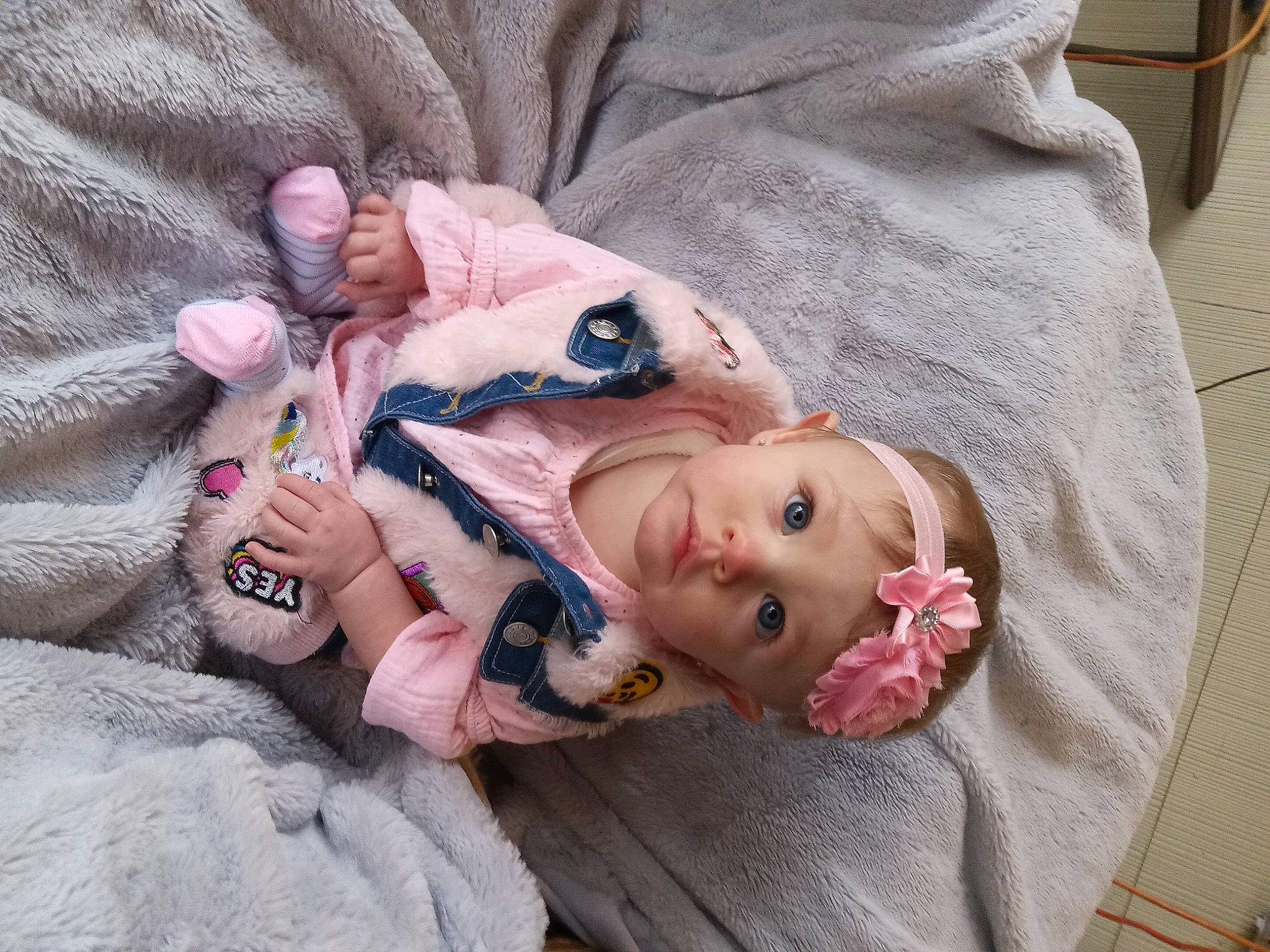 Sabrina is registered to the contest to win money with this photo: baby, baby_products, baby_toddler_clothing, cheek, child, comfort, doll, eye, fur, grass, head, headwear, linens, person, pink, sitting, skin, sleeve, textile, toddler