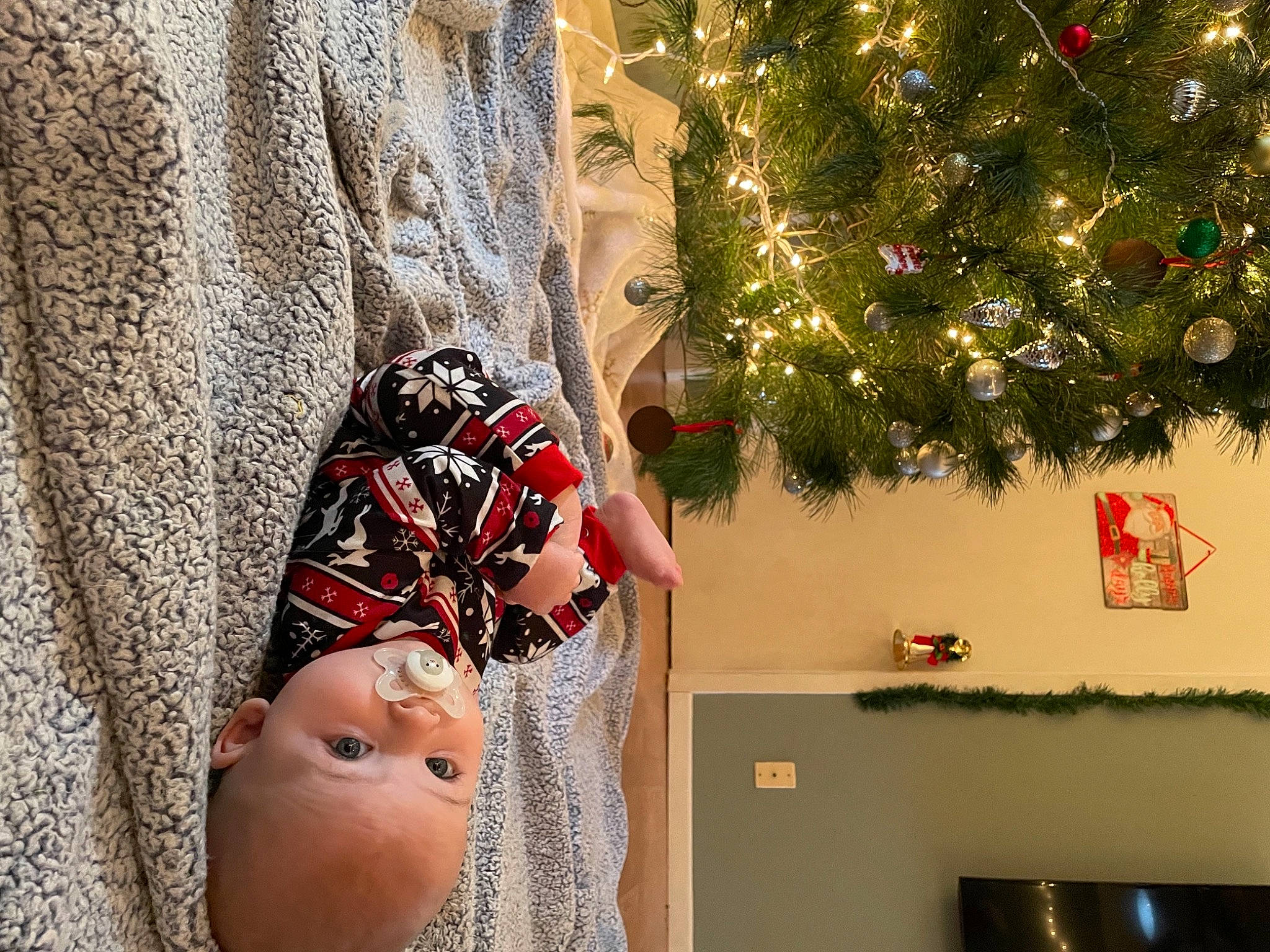Calum is registered to the contest to win money with this photo: baby, baby_toddler_clothing, cap, christmas, christmas_decoration, christmas_ornament, christmas_tree, event, happy, hat, holiday_ornament, human_body, interior_design, ornament, plant, toddler, tradition, tree, white, wood