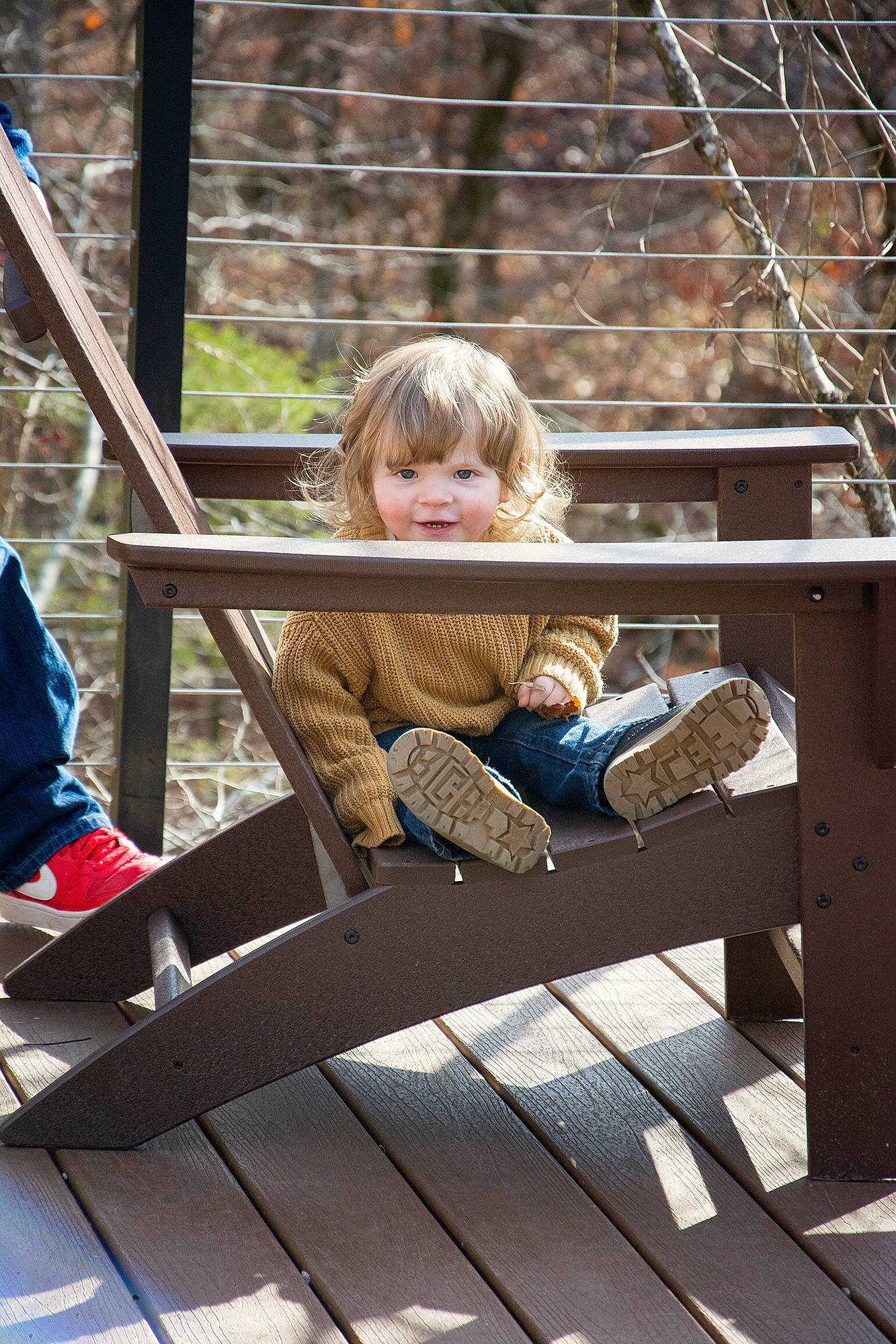 Clarence is registered to the contest to win money with this photo: blond, bridge, child, clothing, deck, fun, grass, happy, leaf, leisure, outdoor_furniture, pattern, people_in_nature, person, public_space, recreation, sitting, smile, toddler, vacation