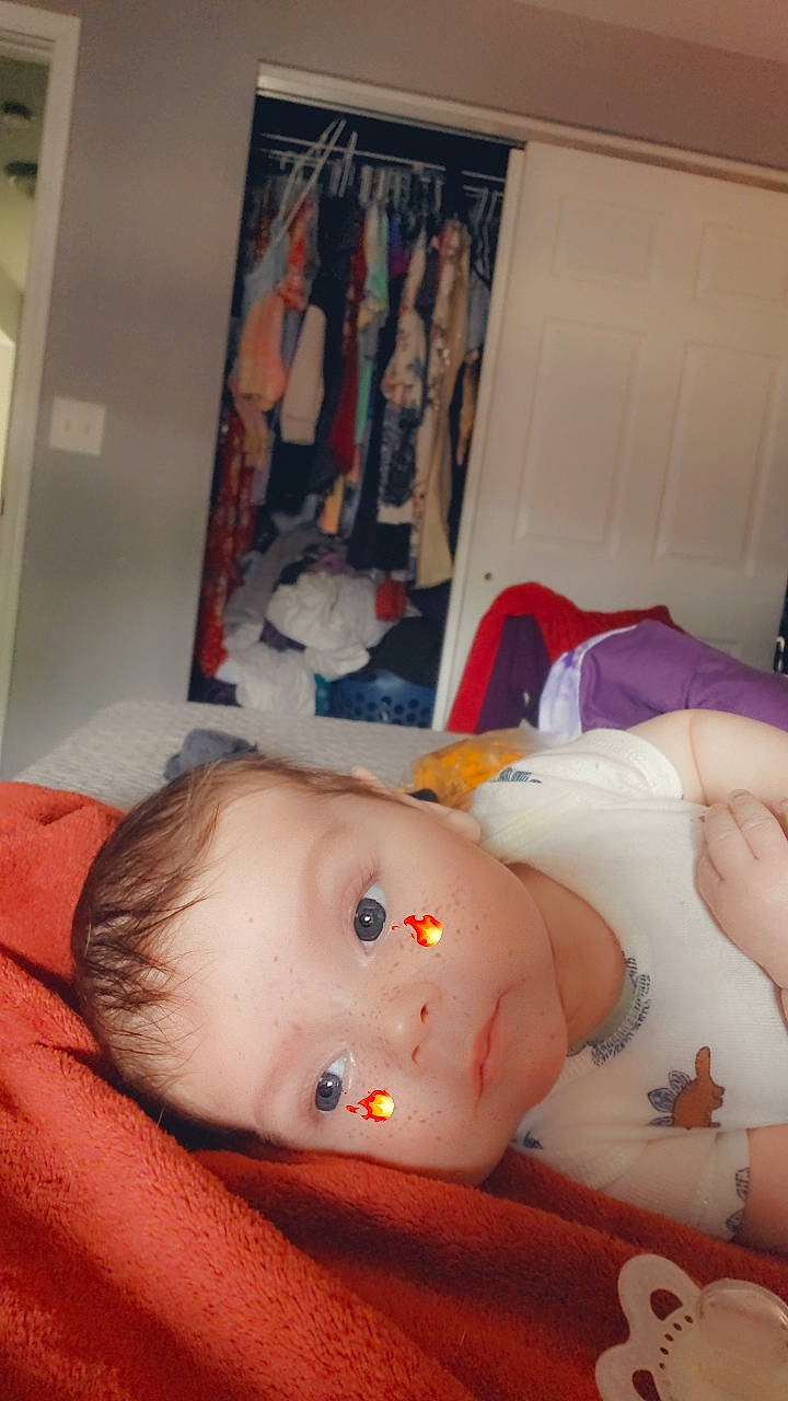 Isaiah is registered to the contest to win money with this photo: abdomen, baby, cheek, chest, child, comfort, eyebrow, eyelash, flesh, lip, mouth, neck, nose, orange, person, room, stomach, throat, thumb, toddler