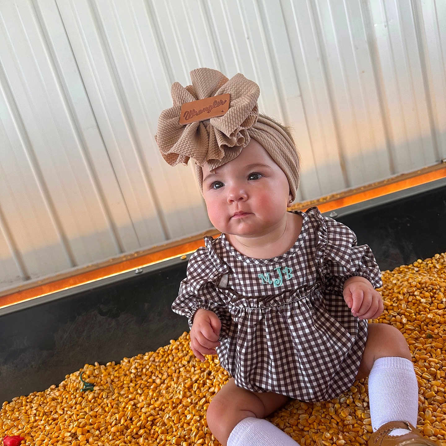 Maisie is registered to the contest to win money with this photo: baby, clothing, corn, costume, dress, face, food, footwear, grain, happy, head, person, photography, plant, portrait, produce, shoe, sitting, sleeve, smile