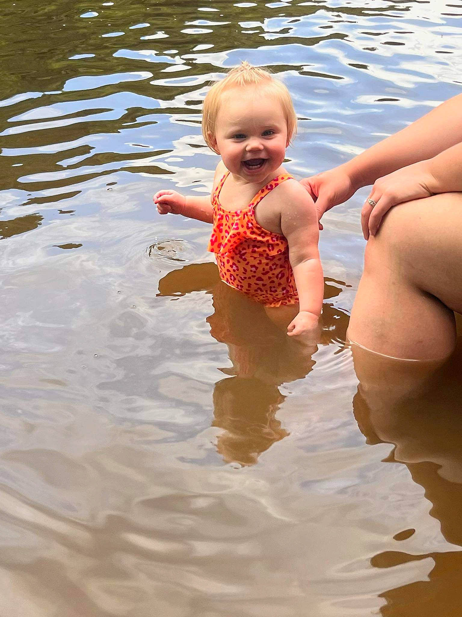 Kristina is registered to the contest to win money with this photo: bathing, chest, child, eye, face, finger, fun, happy, joy, lake, leisure, people_in_nature, people_on_beach, person, recreation, skin, smile, swimwear, thigh, toddler