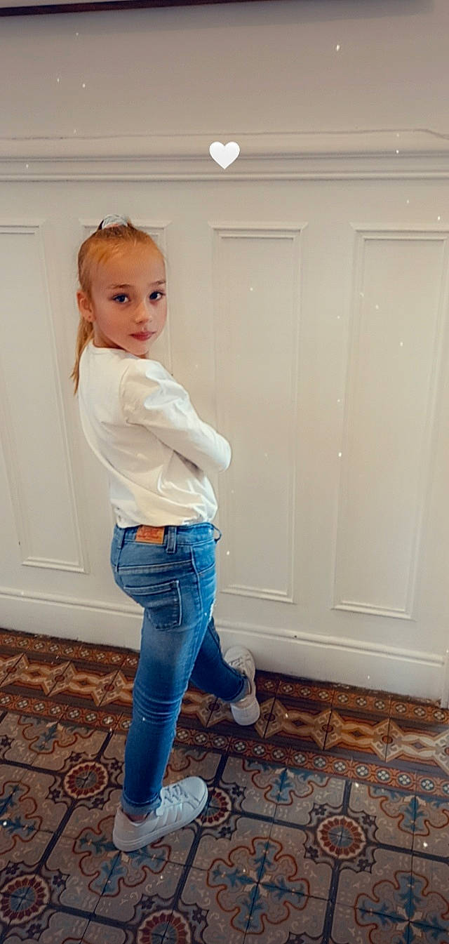 Léna participe au concours pour gagner de l'argent avec cette photo : blond, denim, door, electric_blue, fashion_design, floor, flooring, hardwood, human_leg, jeans, knee, leg, long_hair, person, shoulder, sleeve, t_shirt, thigh, trunk, waist