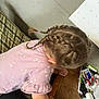 Xalia is registered to the contest to win money with this photo: child, braided_hair, pink_shirt, wooden_surface, calendar, table, indoor, curious, leaning, clothing, person, hair_ties, paper, documents, casual, messy, furniture, hand, photo, electronics