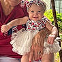 baby, child, woman, smile, headband, dress, tutu, outdoor, garden, greenery, hand, red_shirt, stars, sitting, person, happy, portrait, family, closeup, accessory