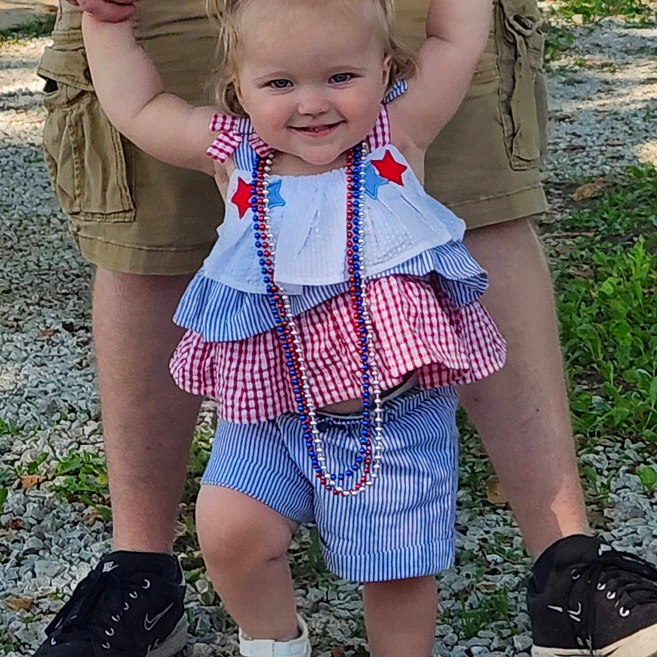 Olivianah is registered to the contest to win money with this photo: adult, beads, blue, child, gravel, hair_bows, happy, holding_hands, legs, necklace, outdoor, person, red, shorts, smiling, sneakers, summer_clothing, toddler, walking, white