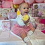 baby, balloons, birthday, celebration, child, cupcake, decorations, face, gift_wrap, happy, headband, indoor, party, pink_tutu, presents, sitting, smiling, socks, tablecloth, toddler
