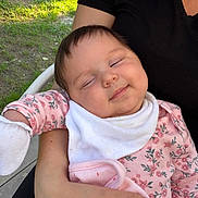 Luna joined the competition — help win amazing prizes! baby, infant, child, sleepy, smiling, portrait, outdoor, family, adult, arms, floral_outfit, bib, pink_clothing, blanket, grass, sunlight, patio, seated, close_up, happy