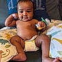 baby, infant, diaper, couch, pillow, animal_print, pacifier, cute, chubby, smiling, indoor, child, skin, face, hand, foot, furniture, comfort, relaxing, playful