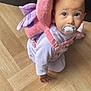 baby, pacifier, crawling, plush_backpack, pink, butterfly, wooden_floor, indoors, child, cute, infant, clothing, person, young_child, face, head, eyes, hand, toy, flooring