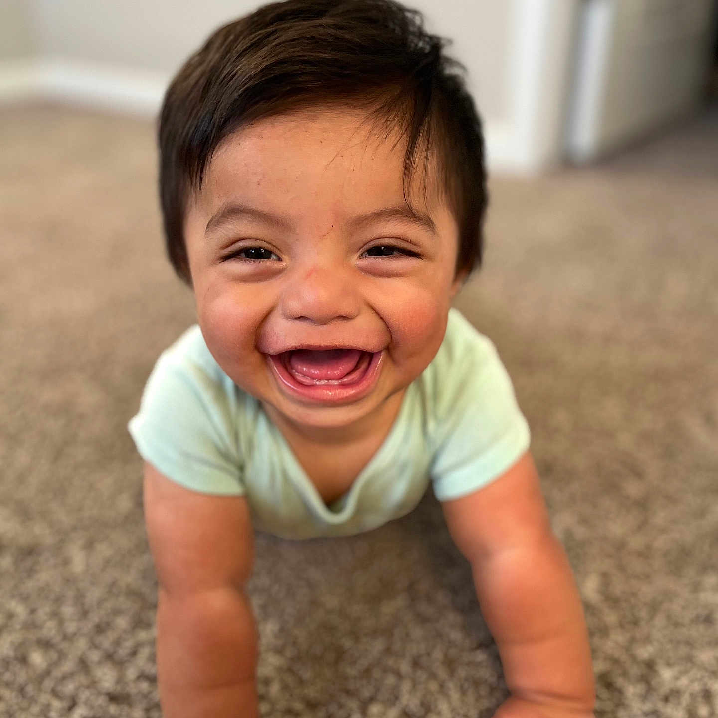 Santiago is registered to the contest to win money with this photo: baby, carpet, child, clothing, crawling, cute, expression, face, floor, hand, happy, home, indoors, infant, person, short_sleeve, skin, smiling, toddler, young_child