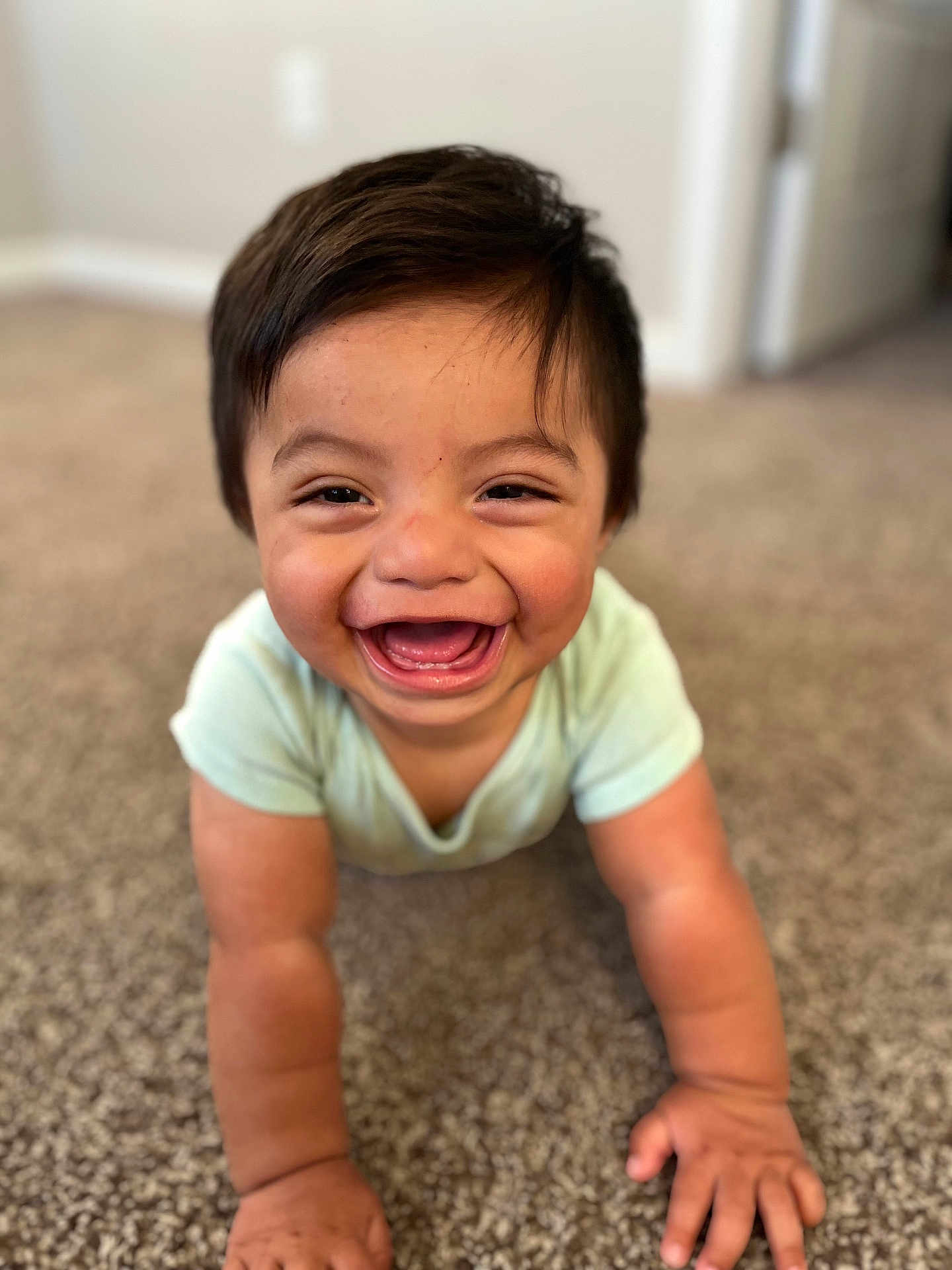Santiago is registered to the contest to win money with this photo: baby, child, crawling, carpet, smiling, happy, indoors, person, infant, cute, toddler, young_child, face, skin, hand, short_sleeve, clothing, floor, home, expression